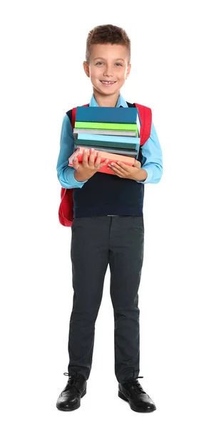 Niño feliz en uniforme escolar con pila de libros sobre fondo blanco — Foto de Stock