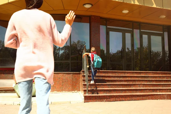 Joven madre viendo a su pequeño hijo fuera de la escuela al aire libre —  Fotos de Stock