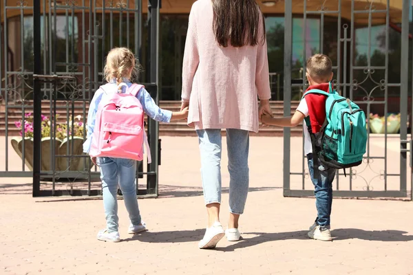 Joven madre llevando a sus hijos a la escuela al aire libre —  Fotos de Stock