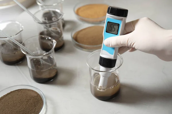 Para ilmuwan mengukur keasaman dan pH tanah di meja, closeup. Analisis laboratorium — Stok Foto