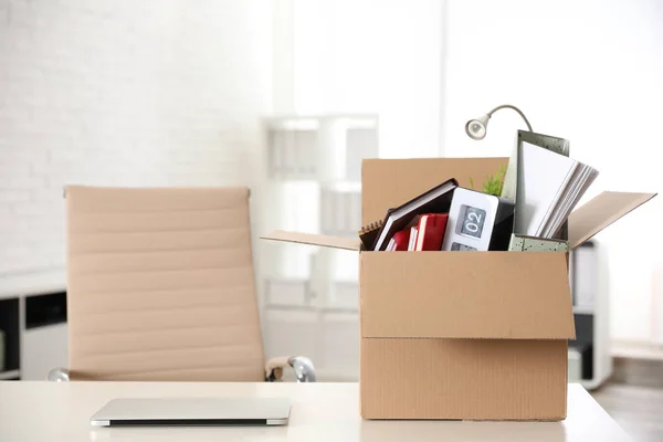 Caja de cartón llena de cosas en la mesa en la oficina — Foto de Stock