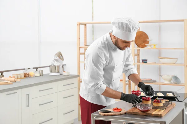 Chef de pastelaria masculino preparando sobremesas à mesa na cozinha. Espaço para texto — Fotografia de Stock