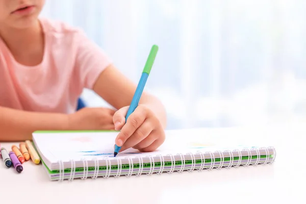 Piccola ragazza mancina che disegna a tavola in camera, primo piano — Foto Stock