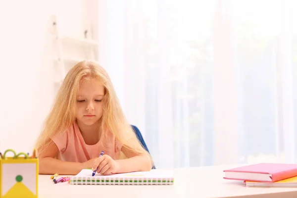 Petite fille gauchère bouleversée dessinant à table dans la chambre — Photo