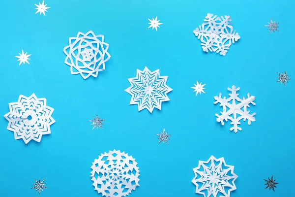 Composição de leigos planos com flocos de neve de papel no fundo azul. Temporada de Inverno — Fotografia de Stock