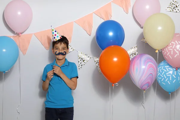 Happy boy near bright balloons at birthday party indoors — ストック写真