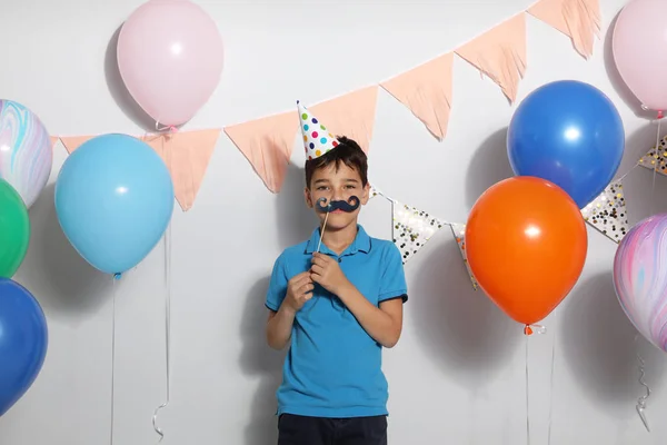 Szczęśliwy chłopiec w pobliżu jasne balony na urodziny w pomieszczeniach — Zdjęcie stockowe