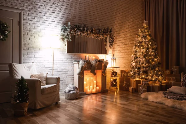 Stilvolles Interieur mit wunderschönem Weihnachtsbaum und künstlichem Kamin in der Nacht — Stockfoto