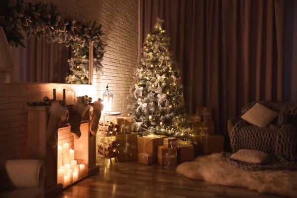 Stilvolles Interieur mit wunderschönem Weihnachtsbaum und künstlichem Kamin in der Nacht — Stockfoto