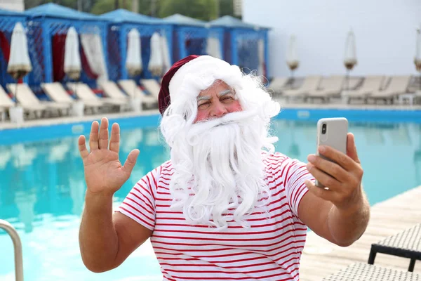 Otantik Noel Baba açık yüzme havuzu yakınında selfie çekerken — Stok fotoğraf