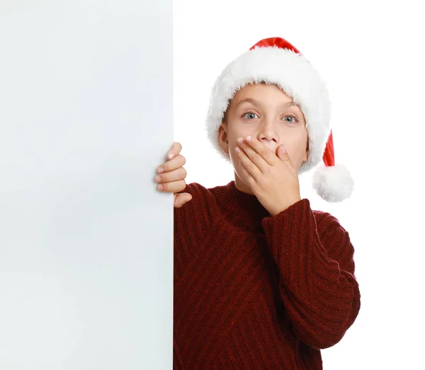 Емоційна дитина в капелюсі Санта з порожнім банером на білому тлі. Святкування Різдва — стокове фото