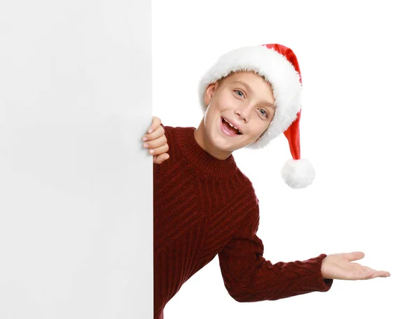 Criança feliz em chapéu de Papai Noel espreitando fora do banner em branco no fundo branco. Celebração de Natal — Fotografia de Stock