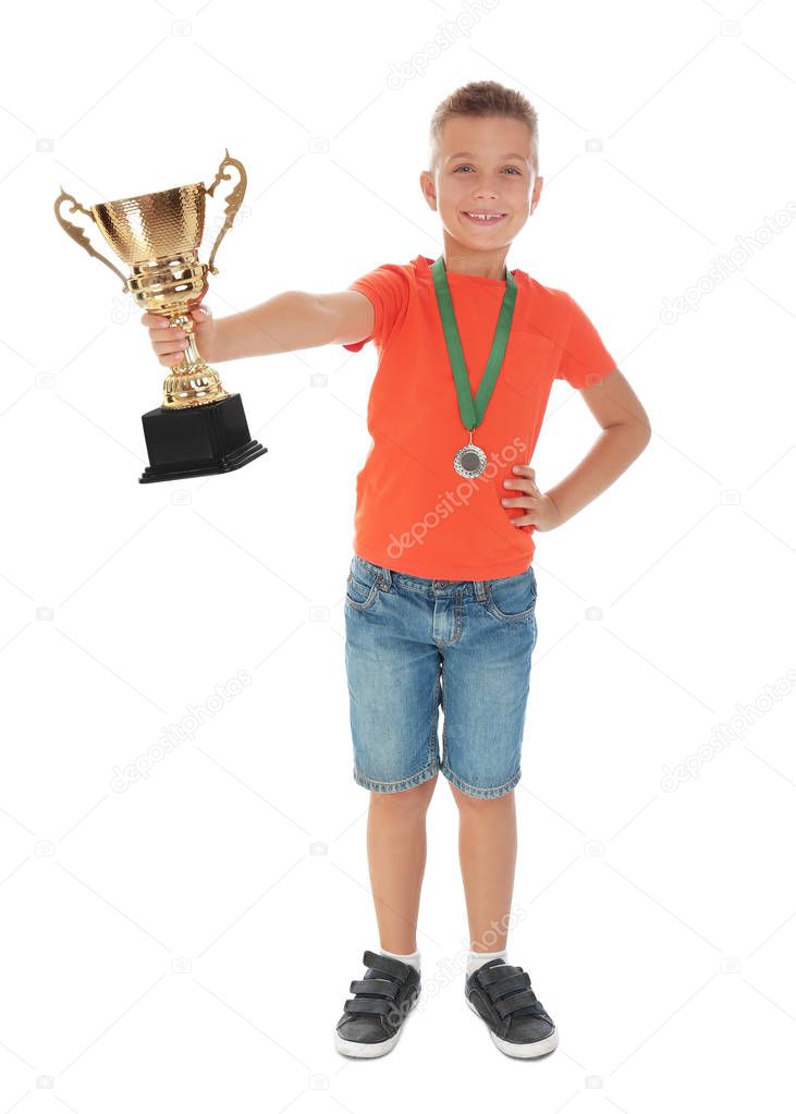 Happy boy with golden winning cup and medal isolated on white