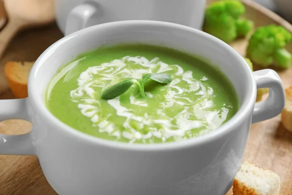Ciotola di deliziosa zuppa di crema di broccoli con microverdi servita su vassoio, primo piano — Foto Stock