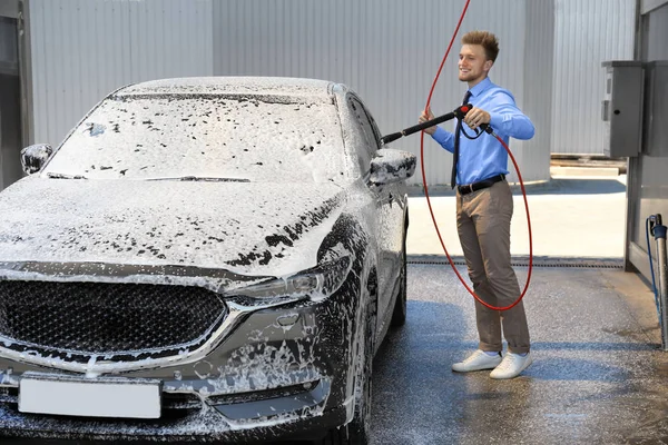 셀프 서비스 세차장에서 고압 워터 제트로 자동차를 청소하는 사업가 — 스톡 사진