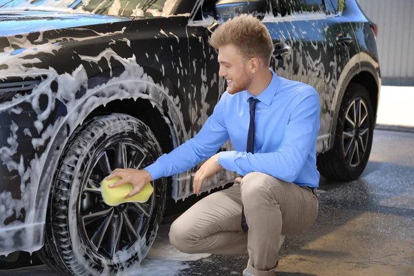 Businessman cleaning auto with sponge at self-service car wash — Stock Photo, Image