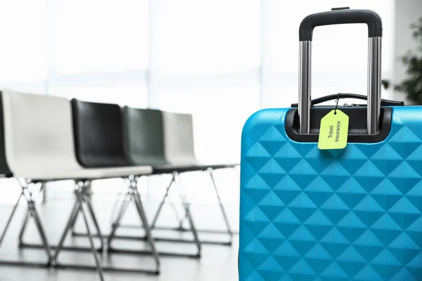 Modrý kufr s nálepkou Cestovní pojištění uvnitř, detailní záběr. Mezera pro text — Stock fotografie