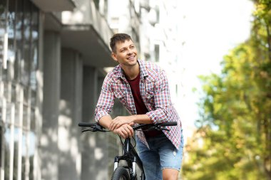 Şehir caddesinde modern bisiklet ile Yakışıklı adam