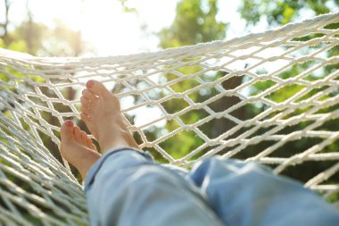 Yeşil bahçede rahat hamakta dinlenen genç kadın, yakın çekim