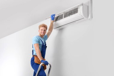 Modern klimayı iç mekanlarda koruyan profesyonel teknisyen