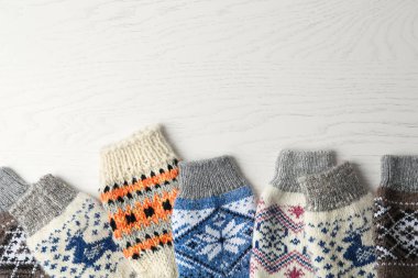 Beyaz ahşap arka plan üzerinde yumuşak örme çorap, düz metin için boşluk yatıyordu. Kışlık giysiler