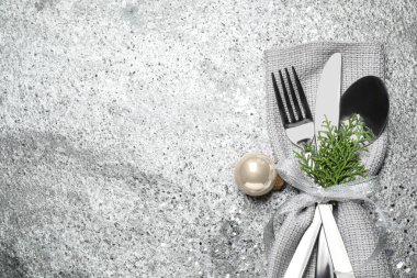 Çatal bıçak seti gri desenli sehpada, üst görünümde yazı için yer var. Noel kutlaması