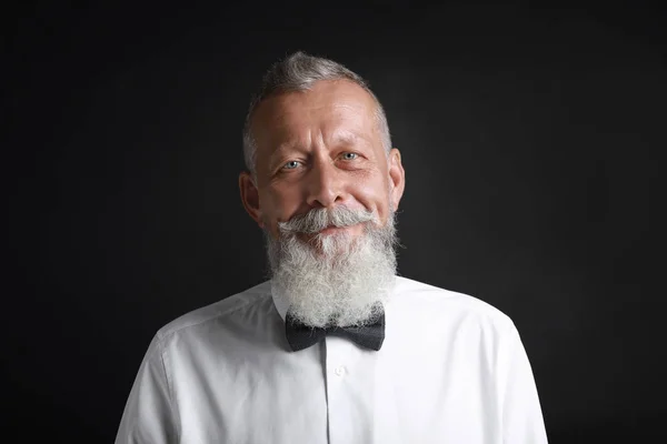 Porträt eines hübschen älteren Mannes auf schwarzem Hintergrund — Stockfoto
