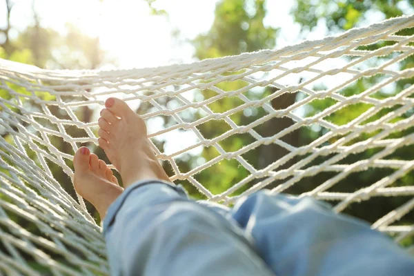 Yeşil bahçede rahat hamakta dinlenen genç kadın, yakın çekim