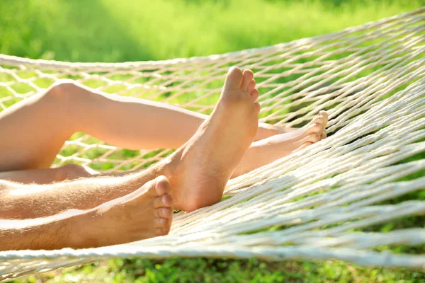 Casal jovem descansando em rede confortável no jardim verde, close-up — Fotografia de Stock