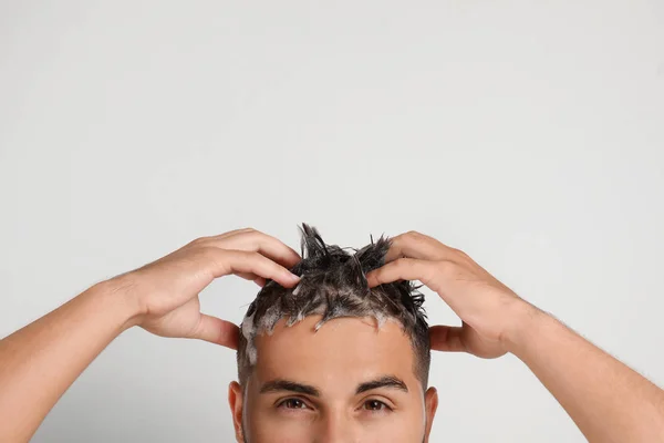 Homem lavando o cabelo no fundo branco, close-up — Fotografia de Stock