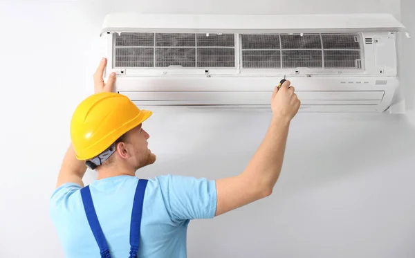 Técnico profissional mantendo ar condicionado moderno dentro de casa — Fotografia de Stock