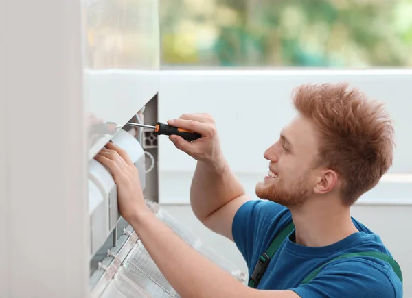 Técnico profissional mantendo ar condicionado moderno dentro de casa — Fotografia de Stock