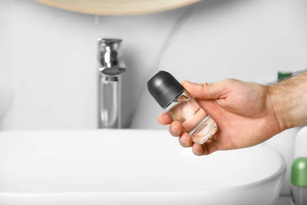 Omul care deține deodorant roll-on în baie, closeup — Fotografie, imagine de stoc