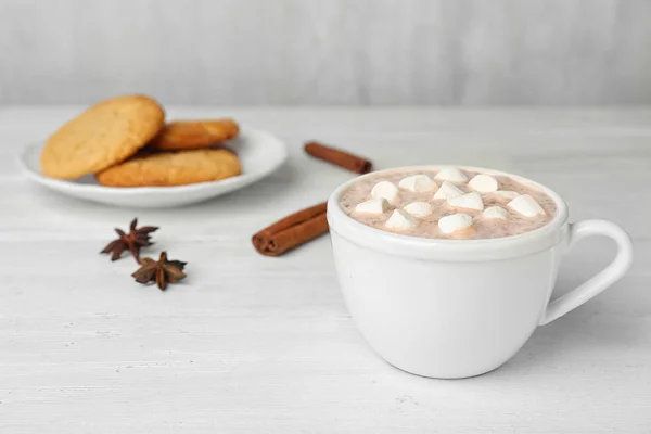 Deliciosa bebida caliente de cacao con malvaviscos en taza sobre mesa de madera blanca —  Fotos de Stock