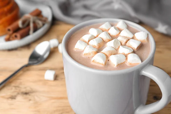 Deliciosa bebida de cacau quente com marshmallows em xícara na mesa de madeira, close-up — Fotografia de Stock