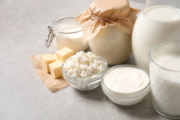 Diferentes deliciosos produtos lácteos na mesa de luz — Fotografia de Stock
