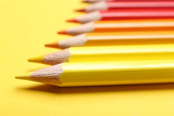 Sarı arka planda farklı renkli kalemler, yakın çekim — Stok fotoğraf