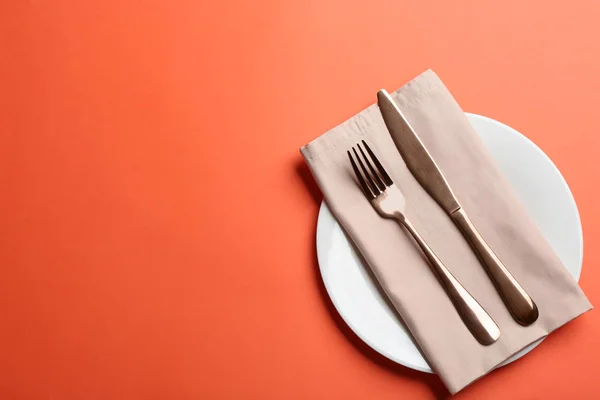 Elegante tavola apparecchiata su sfondo arancione, posata piatta. Spazio per testo — Foto Stock