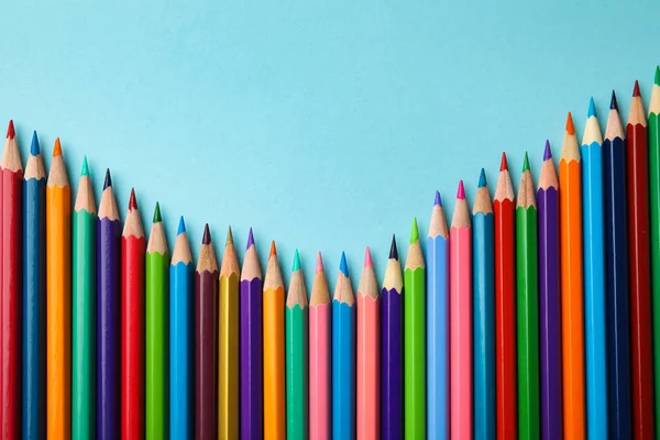 Composición plana con lápices de color sobre fondo azul — Foto de Stock