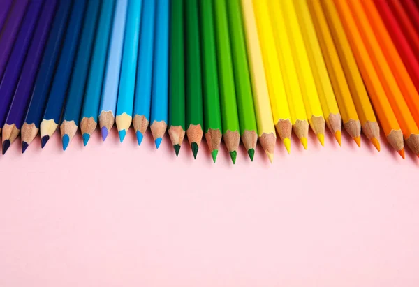 Kompozice s barevnými tužkami na růžovém pozadí — Stock fotografie