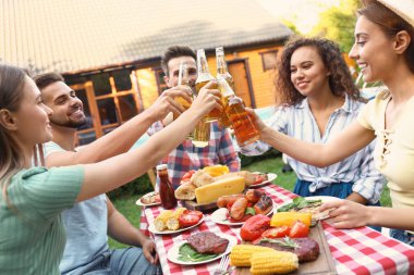 İçkili mutlu arkadaşlar dışarıda barbekü partisinde eğleniyorlar.