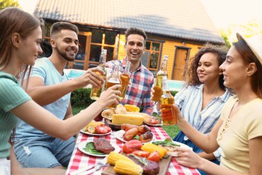 İçkili mutlu arkadaşlar dışarıda barbekü partisinde eğleniyorlar.