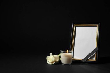 Funeral photo frame with ribbon, white rose and candle on black background. Space for design clipart
