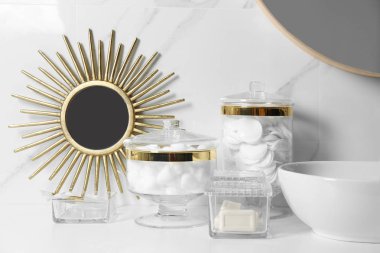 Banyodaki beyaz tezgahta pamuk topları ve pedlerle kompozisyon