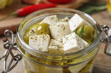 Kavanozda salamura peynir, ahşap masada, yakın plan.