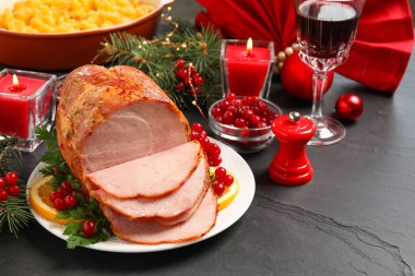 Lezzetli bir Noel jambonu, karanlık masada garnitürle servis edilir.