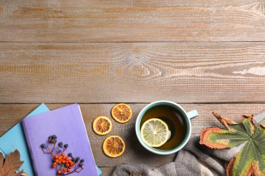 Düz kompozisyon, bir fincan sıcak içecekle ahşap masada, metin için boşluk. Sıcak sonbahar atmosferi