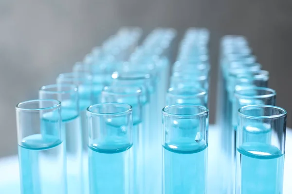 Muitos tubos de ensaio com líquido azul claro, close-up — Fotografia de Stock