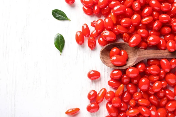 Composição de colocação plana com bagas de goji maduras frescas na mesa de madeira branca. Espaço para texto — Fotografia de Stock