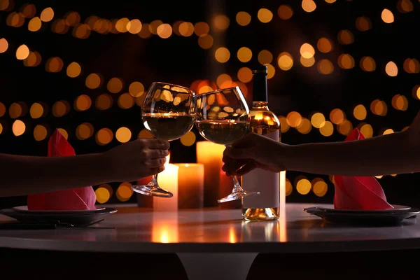 Koppel met een glas wijn met romantisch diner bij kaarslicht aan tafel, close-up — Stockfoto